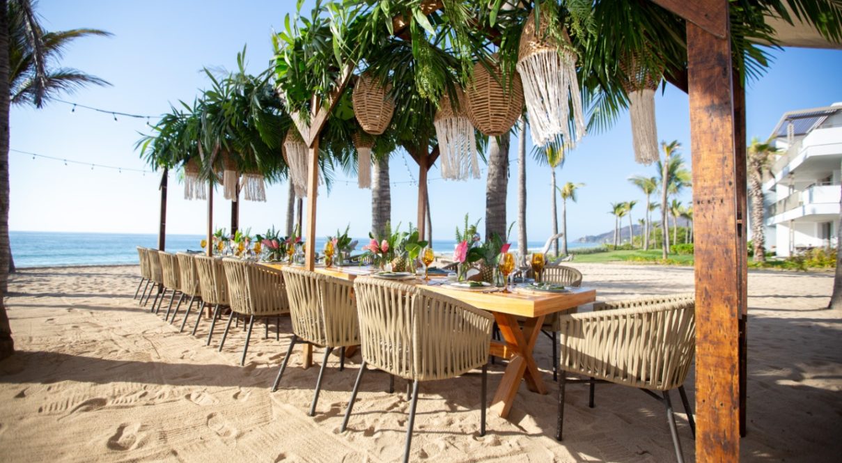 Picture of dining table on the beach with the sea view.